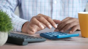 Persona calculando con una calculadora la revisión de su hipoteca variable en 2026
